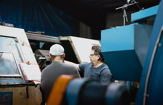 Employees looking at a CNC machine